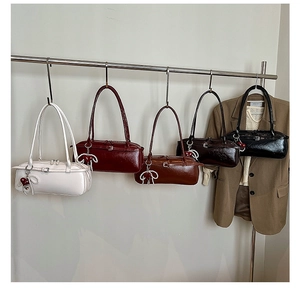 Detail view of stylish baguette bags in various colors with elegant pearl heart charms