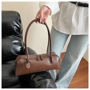 Detail view of smooth dark brown leather shoulder bag with double zippers and top handles