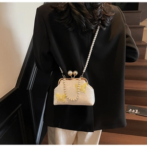 Détail du sac coquille en jacquard blanc avec papillons 3D et bandoulière en perles