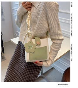 Detail of crossbody mini bag with cream and green contrast and silk scarf strap decor