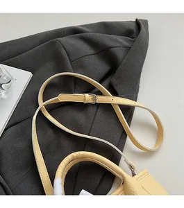 Detail of adjustable strap and silver buckle on cream lychee texture bucket bag