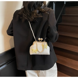 Détail du sac coquillage en jacquard blanc avec papillon jaune et bandoulière perle