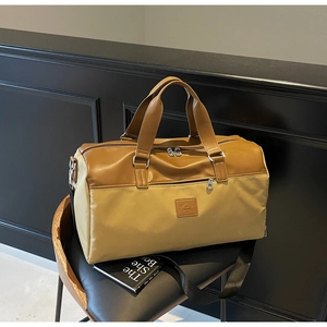 Detail of contrast stitch travel bag with leather handles on a black modern chair