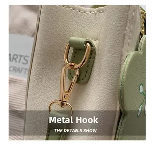 Macro detail of high-quality light gold hardware hooks and stitching on a contrast small bag