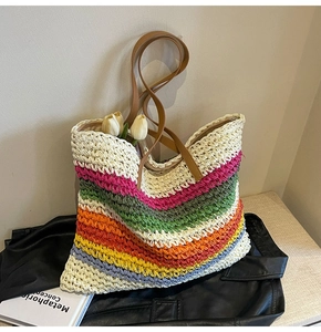 Detailed close-up of rainbow woven tote bag with textured stripes and leather shoulder straps