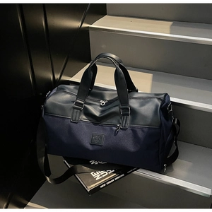 Close-up of a high-capacity travel bag featuring dark blue fabric and black leather trim