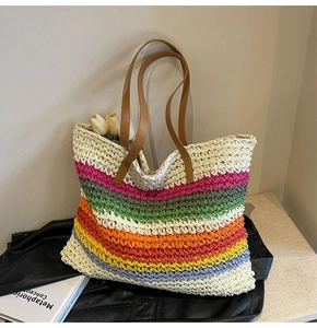 Detailed view of spacious woven rainbow tote bag with brown leather handles and flowers