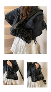 Détails du sac nuage en similicuir noir avec des nœuds décoratifs et des plis élégants