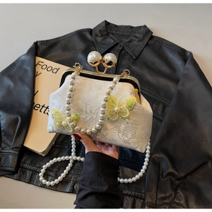Détail du sac coquillage en jacquard blanc avec papillons et fermoir à perles