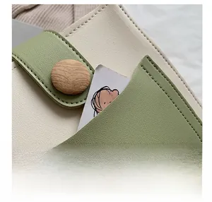 Detailed macro view of the contrast-color leather mini bag with wood grain button closure