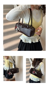 Detail of dark coffee leather shoulder bag with buckle accent and heart keychain charm
