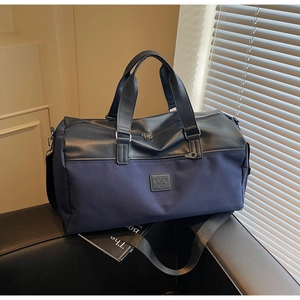 Macro shot of large blue canvas travel bag with leather logo patch and metal hardware