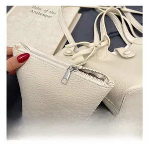 Close-up of cream pebble leather coin purse with silver metal zipper for bucket bag
