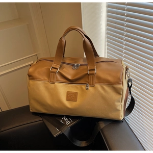 Close-up of contrast large canvas travel bag with faux leather trim and brand logo