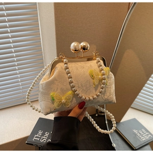 Détails du sac coquille en dentelle blanche avec papillon et poignée en perles