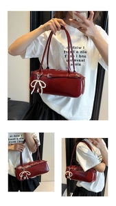 Detail of dark red faux leather pillow bag showing the pearl bow pendant and shoulder strap