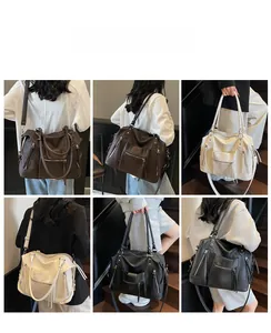 Detail showing litchi texture faux leather, multiple zipper pockets and tassels on tote bag