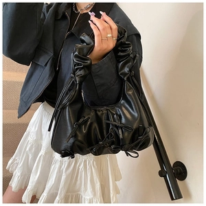 Détail du sac nuage noir plissé avec nœuds en cuir brillant et anse à volants