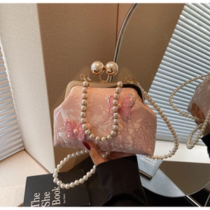 Détail du sac de soirée en dentelle rose clair avec broderie papillon 3D et chaîne perles