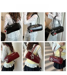 Detail view of glossy leather pillow bag featuring pearl bow and red heart charms