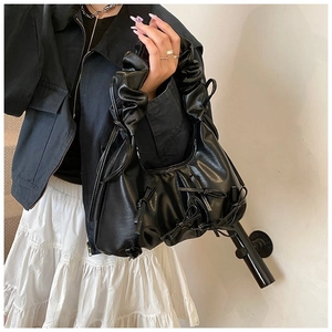 Détail du sac en cuir PU noir avec poignée à froufrous et décorations de nœuds