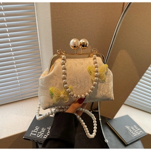 Détail du sac en dentelle blanche avec papillons 3D et bandoulière en perles