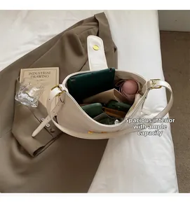 Vue de dessus du sac bandoulière en cuir blanc montrant sa grande capacité pour le quotidien