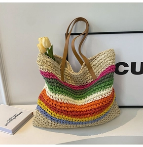Detail of colorful rainbow hand-woven straw tote bag with brown faux leather straps