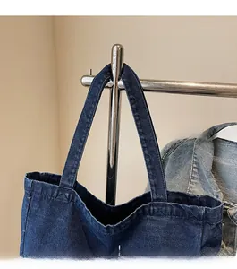 Detail of reinforced wide shoulder strap on dark blue gothic spider web denim tote bag