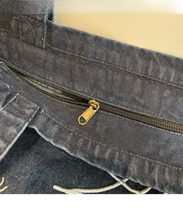 Detailed close-up of premium gold zipper and precise stitching on blue denim bag