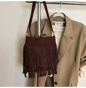 Detail einer dunkelbraunen Wildleder-Fransentasche im Bohemian-Stil mit Quasten