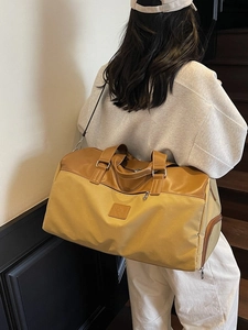 Large yellow canvas travel tote bag with brown leather trim and shoulder strap