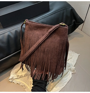 Detailaufnahme der braunen Wildleder-Beuteltasche mit langen Fransen und Goldbeschlägen