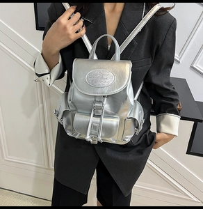 Close-up of metallic silver backpack with magnetic flap and Moon Shark logo