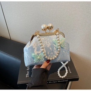 Détail du sac de soirée en dentelle bleu clair avec papillons 3D et fermoir perle