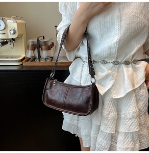 Detail shot of vintage brown oil wax leather bag with silver rivets on shoulder strap