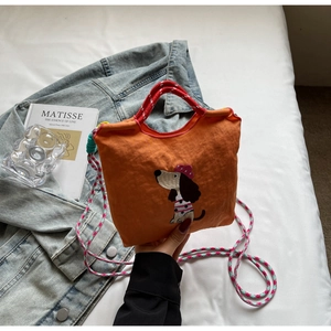 Detail of orange nylon dachshund bag with embroidered cartoon dog and colorful straps