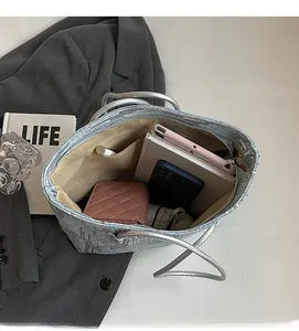 Spacious interior of silver sequin tote bag holding tablet, phone, and accessories