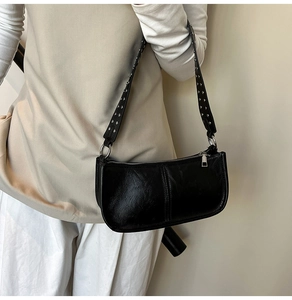 Close-up of black PU leather bag featuring vintage texture and silver rivet shoulder strap