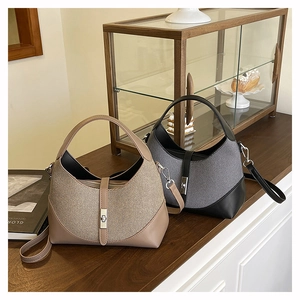 Detail of Boston style straw texture bag with contrast panels and metal twist lock closure