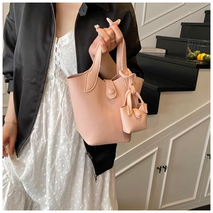 Detail of pink lychee grain leather bucket bag with a matching mini pouch charm accessory