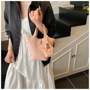 Detail of pink lychee leather bucket bag set with matching mini pouch and handle