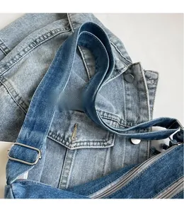 Detailed macro view of the adjustable denim shoulder strap with silver metal buckle