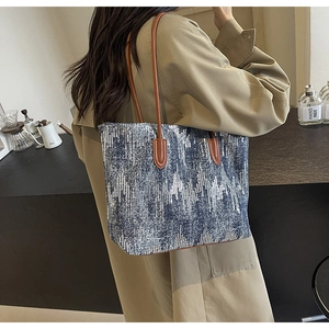 Detail of blue sequin tote bag with textured jacquard fabric and brown leather straps