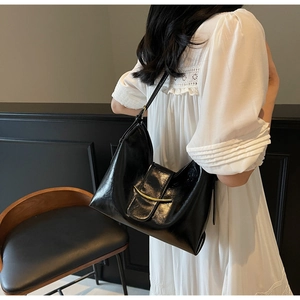 Détail du sac croissant noir élégant avec finitions dorées polies et cuir brillant