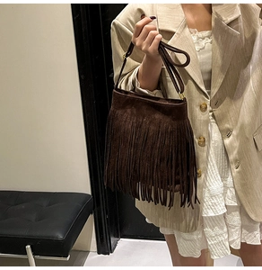 Detailansicht einer dunkelbraunen Wildleder-Beuteltasche mit langen Boho-Fransen und Riemen