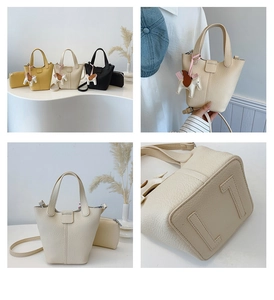 Detailed view of pebbled leather bucket bag with horse charm and sturdy bottom stitching