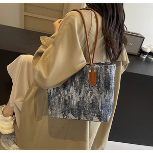 Fashionable denim sequin tote bag with leather shoulder straps worn by model