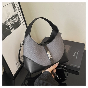 Detail view of contrast stitching and silver twist lock on this minimalist luxury handbag