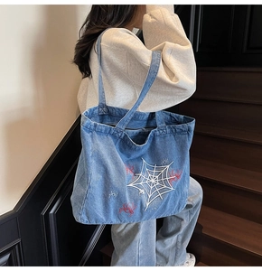 Detail of vintage gothic denim tote bag with spider web embroidery and spacious interior